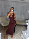 Captivate the room in this stunning burgundy maxi dress, designed to command attention at any upscale evening event. Crafted from a form-fitting, ruched fabric that hugs your curves, this dress features a striking sweetheart neckline accentuated by a bold metallic gold abstract hardware piece at the center. The sleek silhouette flows down into a dramatic floor-length finish with a high side slit, offering both glamour and effortless movement. Pair this showstopper with metallic statement accessories and you